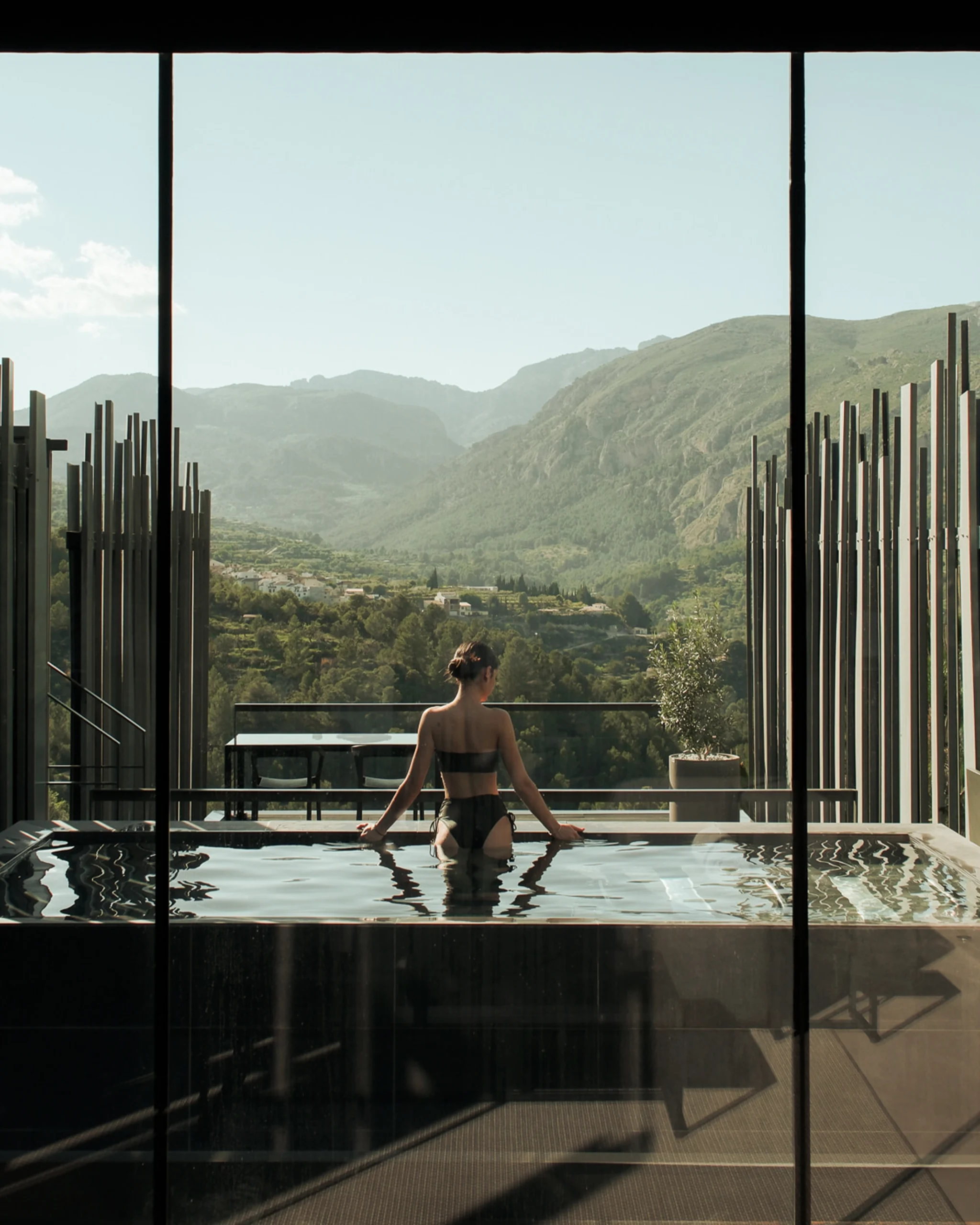 Mujer en jacuzzi privado contemplando el paisaje desde el interior de una villa premium en Alicante.