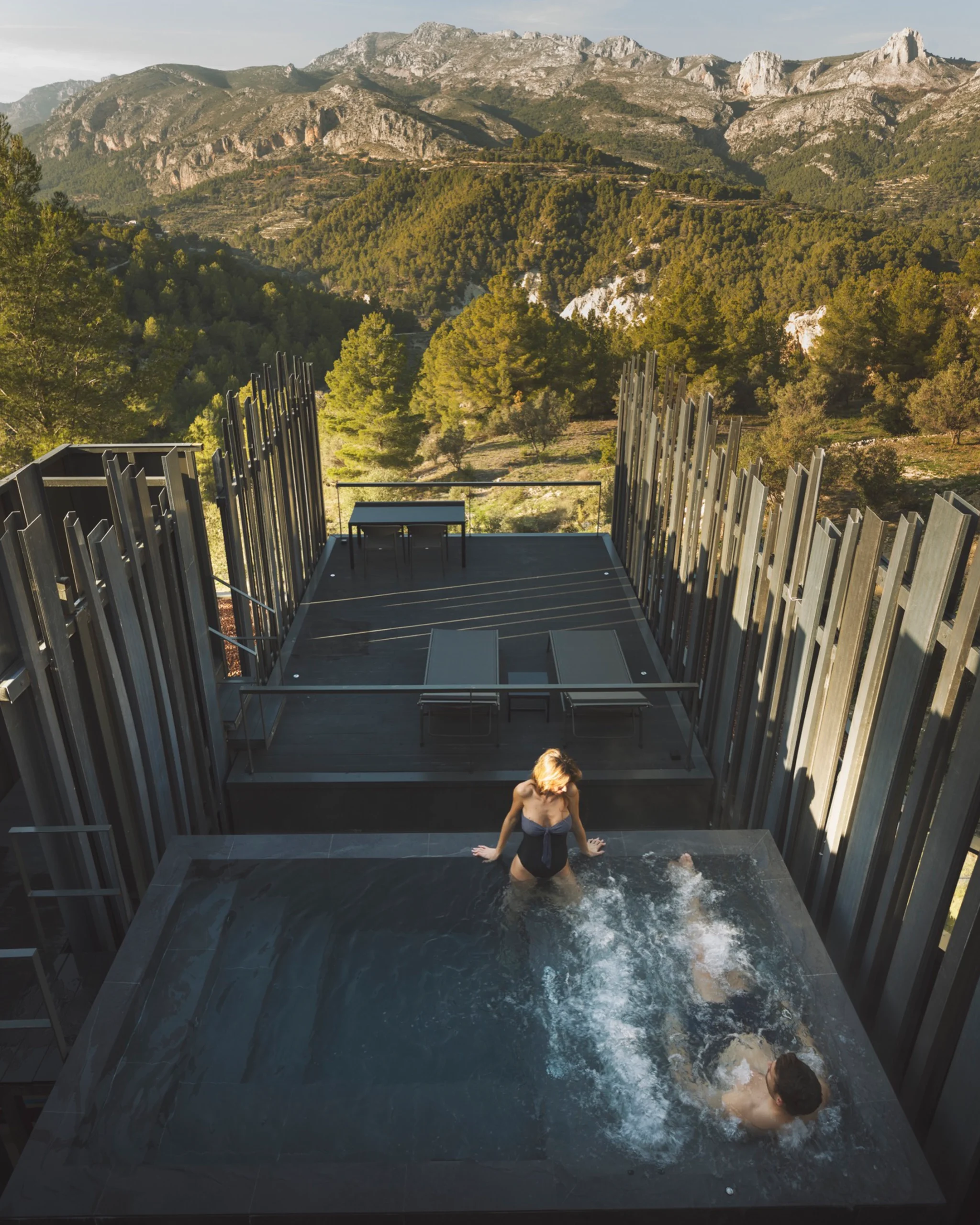 Pareja disfrutando de jacuzzi exterior con vistas a la Sierra en un hotel de lujo en Guadalest.