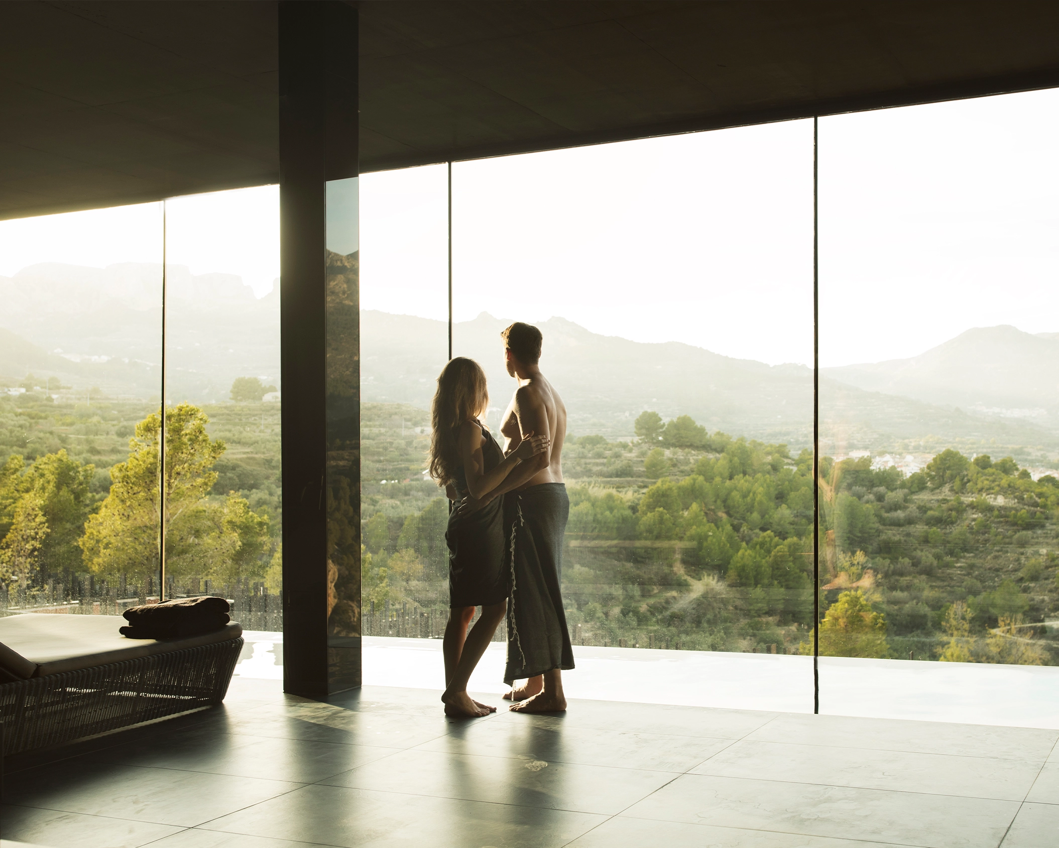 Pareja contemplando el atardecer desde el spa de un hotel boutique en la montaña de Alicante
