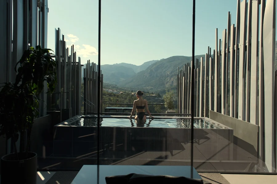 Mujer disfrutando de una piscina privada con vistas a la montaña en VIVOOD Landscape Hotel