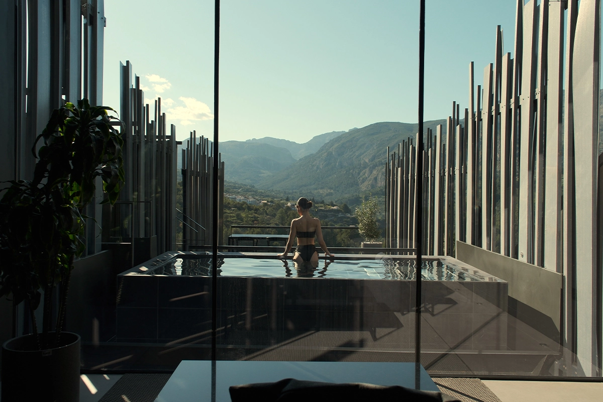 Mujer disfrutando de una piscina privada con vistas a la montaña en VIVOOD Landscape Hotel