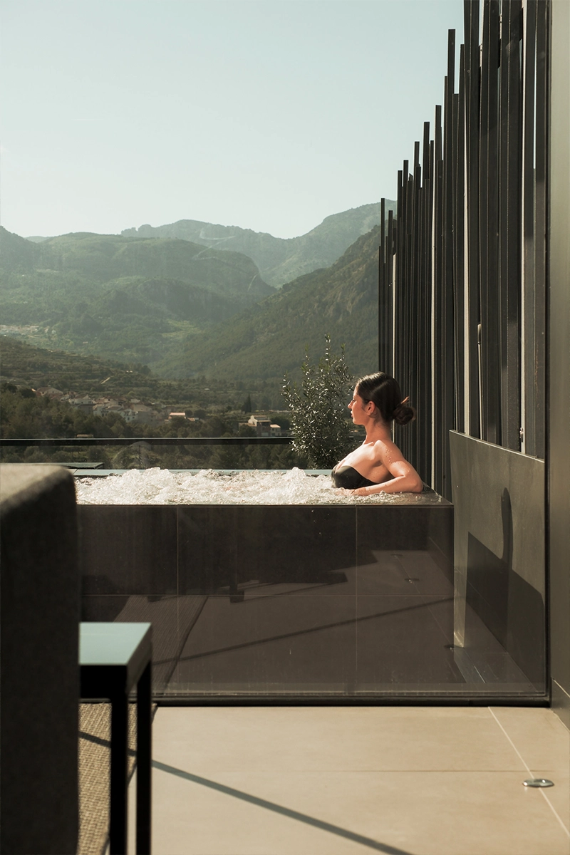Mujer relajándose en un jacuzzi privado con vistas a la montaña
