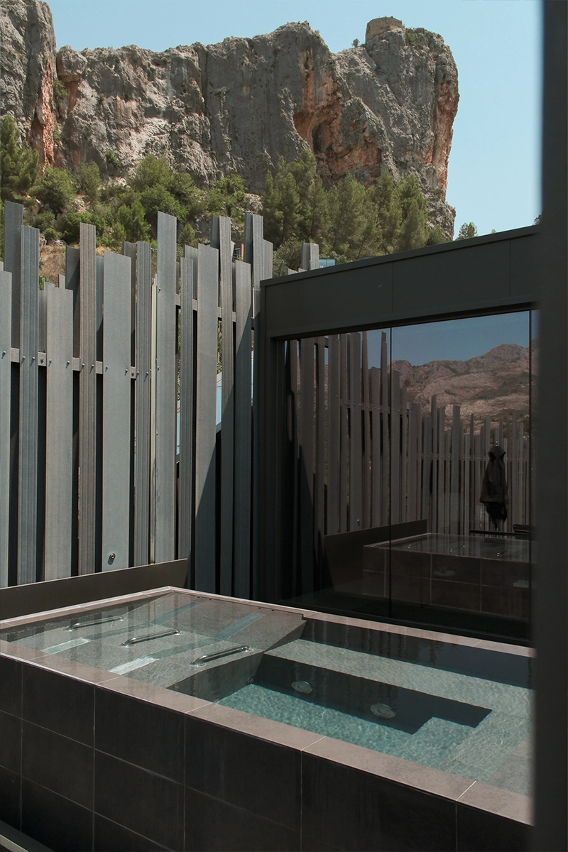 Piscina exterior privada rodeada de arquitectura moderna y naturaleza