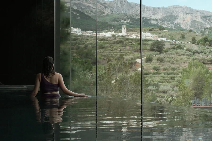 Huesped disfrutando de la piscina climatizada del spa en VIVOOD Alicante con vistas al Valle de Guadalest.