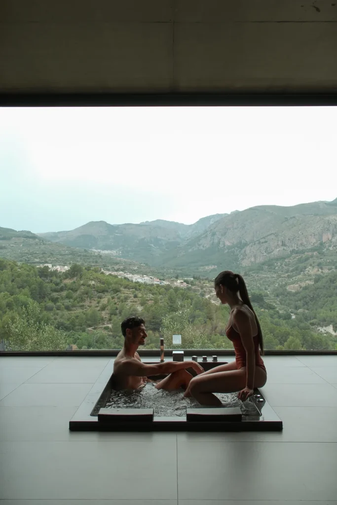 Pareja disfrutando de una experiencia de spa en Alicante con vistas al Valle de Guadalest durante una escapada romántica.