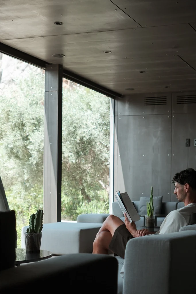 Huésped leyendo en suite con vistas a la naturaleza en VIVOOD, hotel con encanto en Alicante