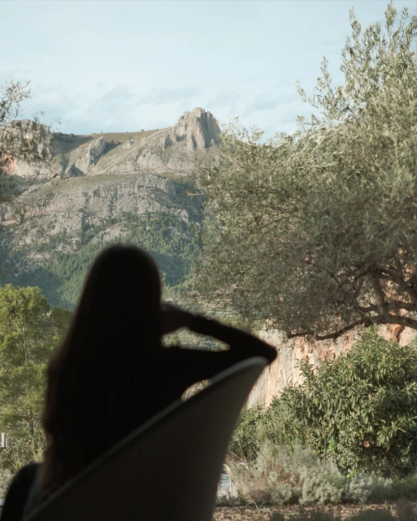 Mujer relajándose mientras observa el paisaje de montaña en el valle de Guadalest