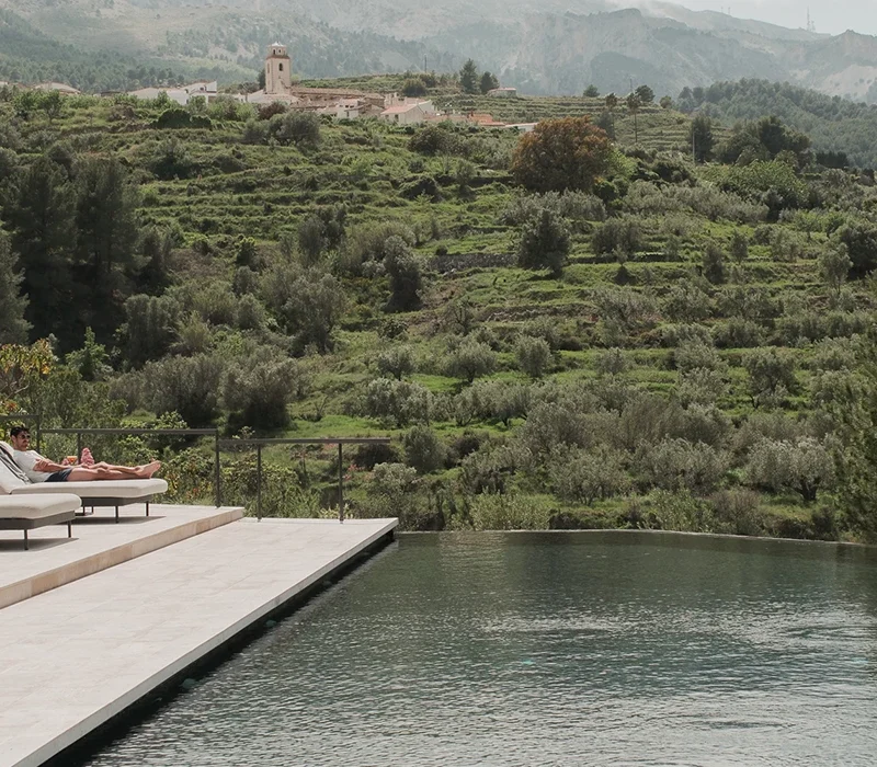Architecture intégrée à la nature dans un hôtel-boutique de luxe à Alicante, avec des villas privées et une vue sur la vallée de Guadalest.