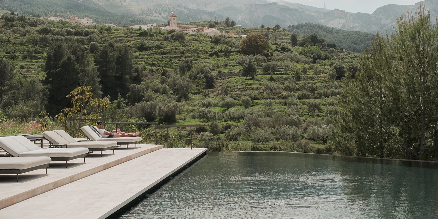 Architecture intégrée à la nature dans un hôtel-boutique de luxe à Alicante, avec des villas privées et une vue sur la vallée de Guadalest.